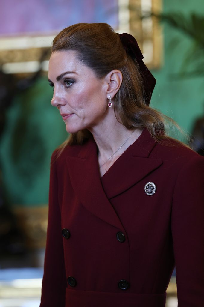 Catherine, Princess of Wales in burgundy side on with bow in hair