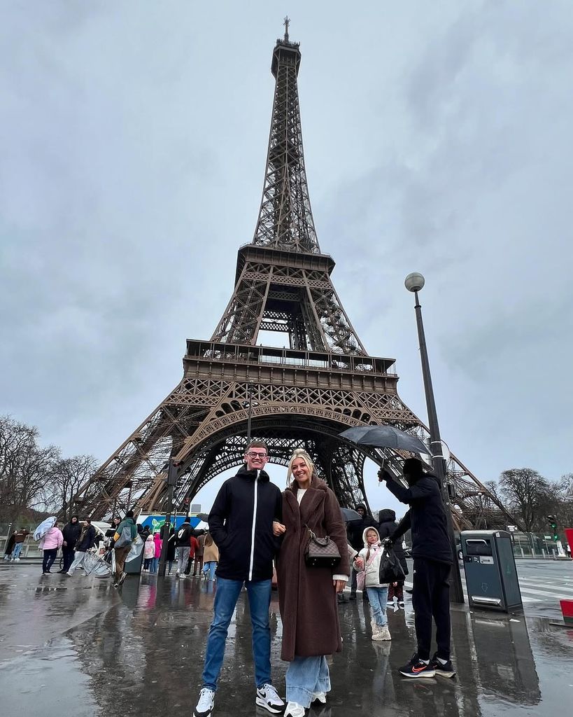 Izzi Warner and guest standing in front of the Eiffel Tower in Paris