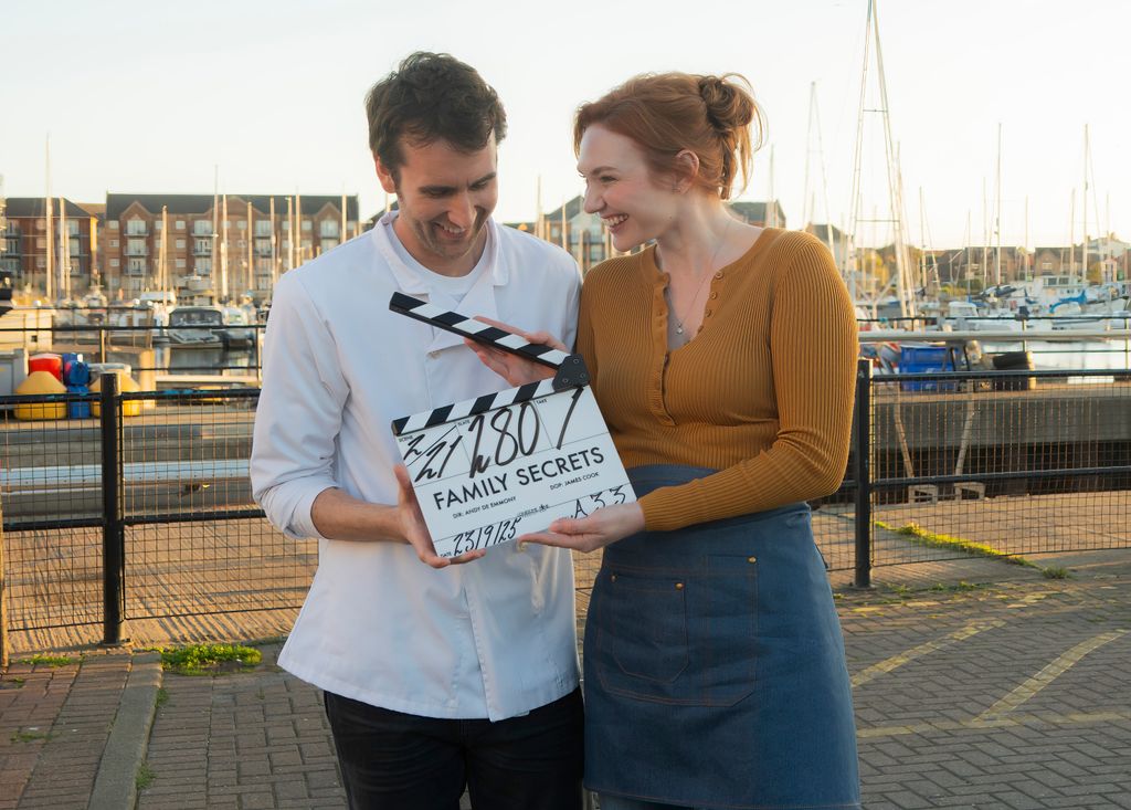 man and woman holding clapperboard