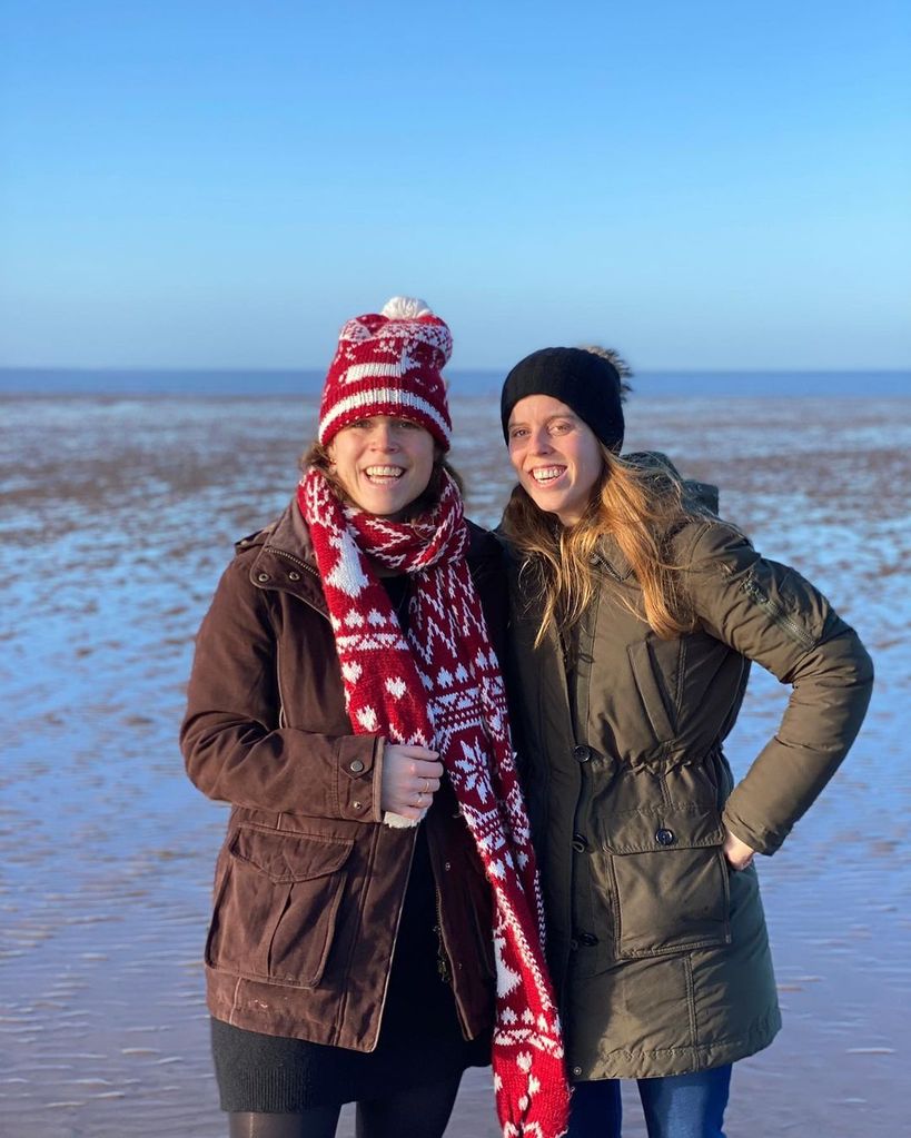 Princesses Eugenie and Beatrice smiling on a beach during the winter