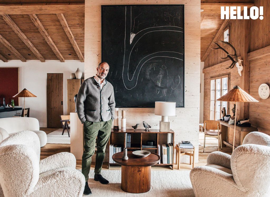 Interior designer Emmanuel is stood up with his hands in his pockets in the double-height living room