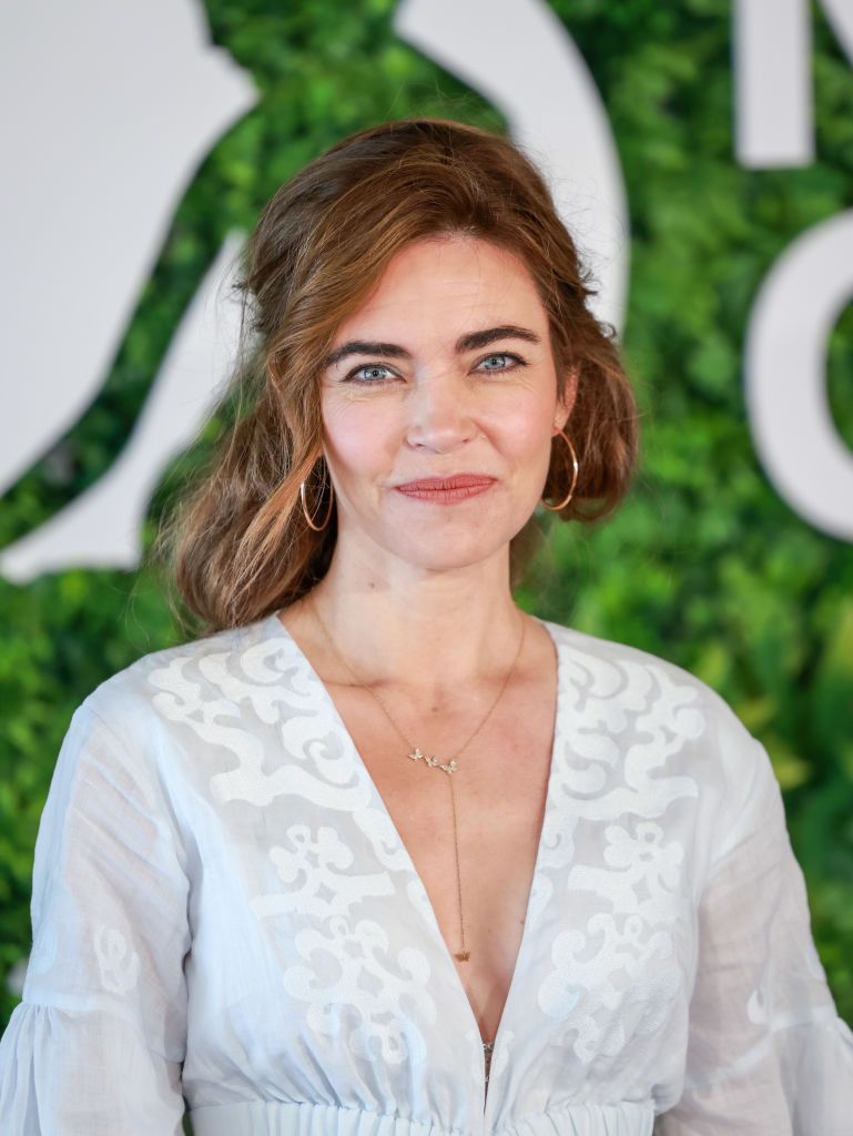 Amelia Heinle smiling. She is wearing a white dress. 