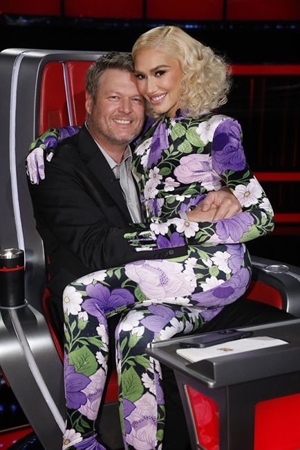 Gwen Stefani sits on Blake Sheltons lap on the voice red chair