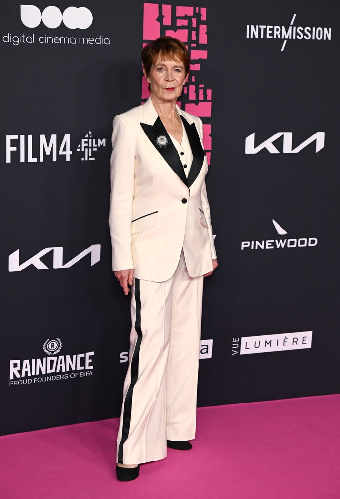 Celia Imrie on pink carpet in black and white suit