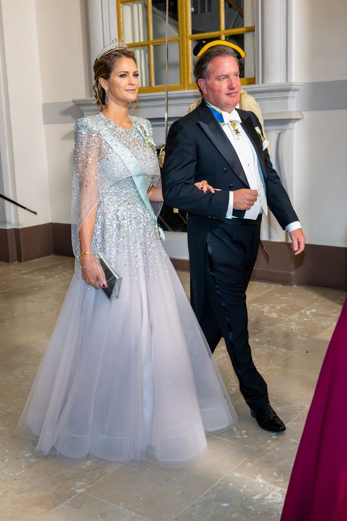 princess Madeleine of Sweden in silver gown and tiara and Christopher O'Neill walking in suit and tails