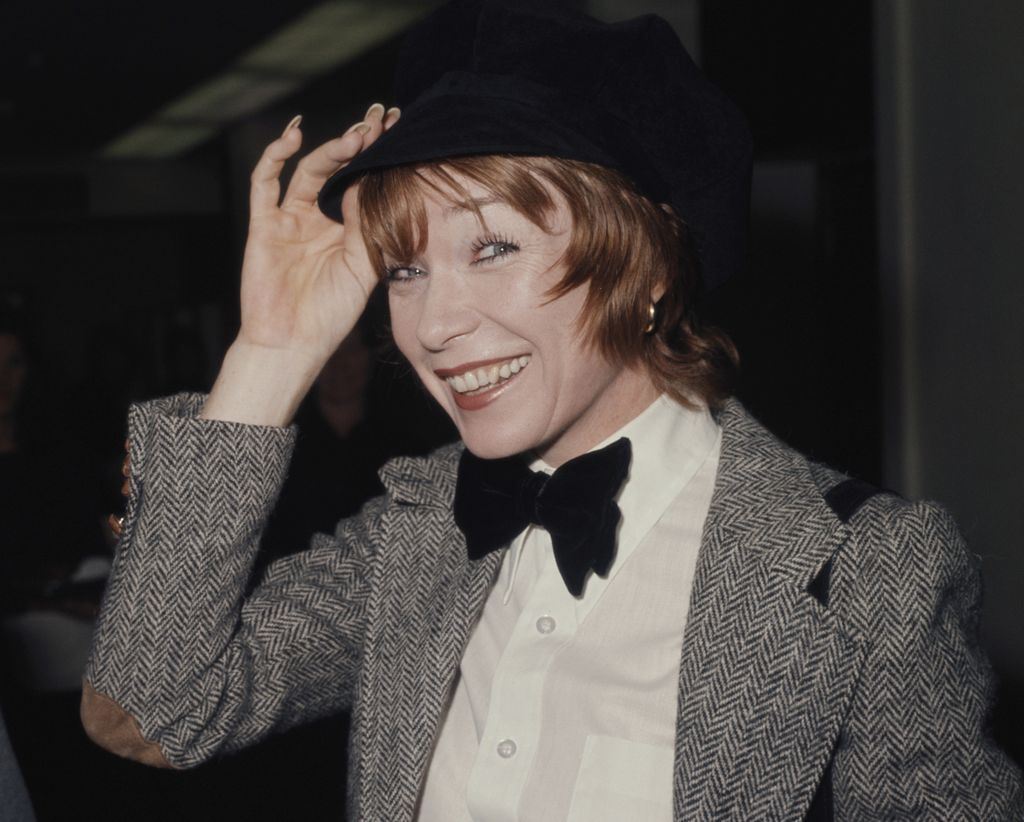 Shirley MacLaine smiling and tipping her hat in a throwback photo