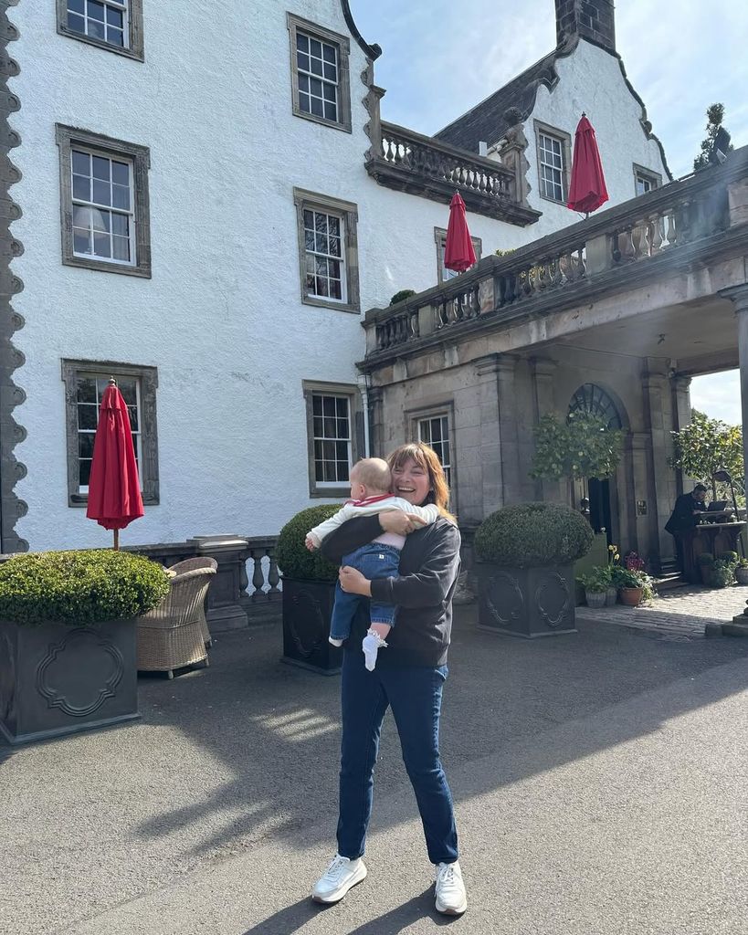 Lorraine Kelly smiling and holding her granddaughter Billie