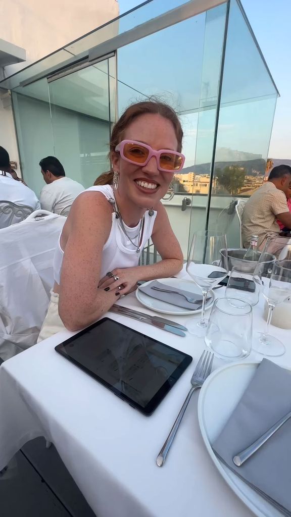 woman sat at table in white outfit 