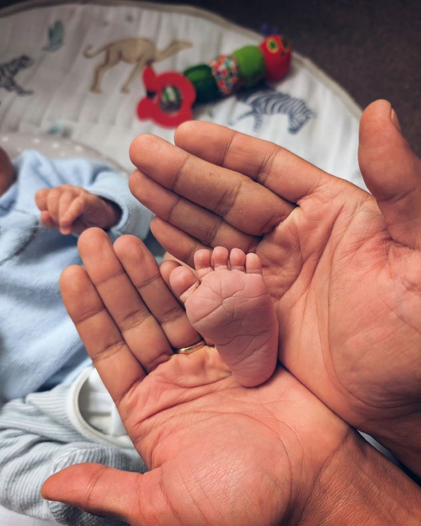 father holding newborn's foot 