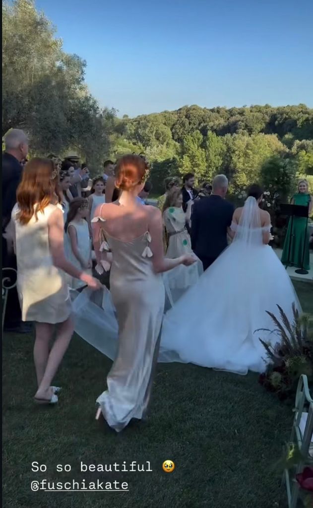 bridesmaids walking aisle behind bride