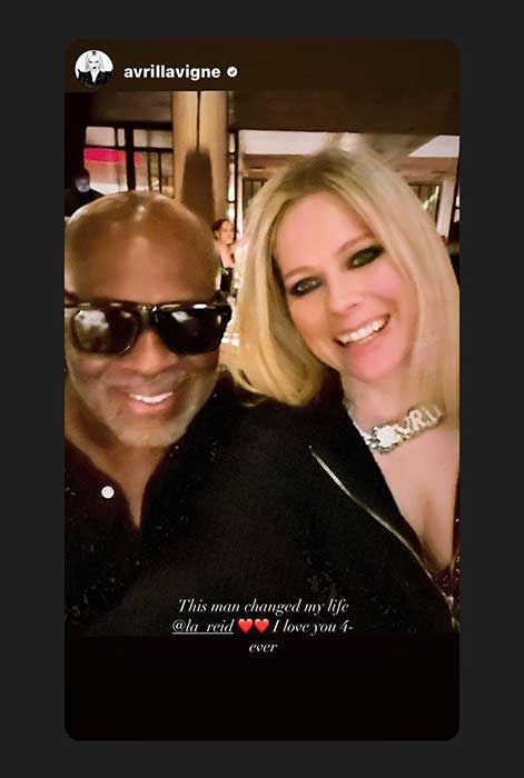 Avril and L.A. Reid leaning in for a selfie together at what appears to be a restaurant. L.A. Reid is wearing dark sunglasses