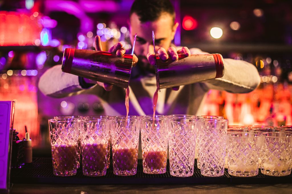 Mixologist pours cocktails