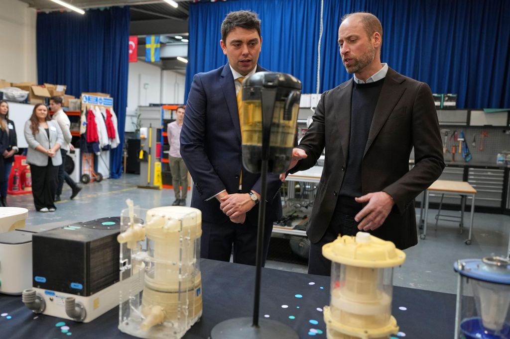 Prince William and a man looking at a technical device
