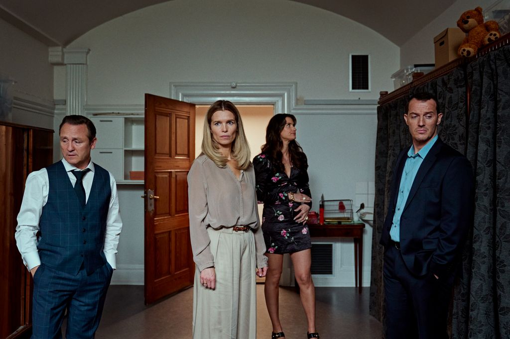 two men, two women in large room in house