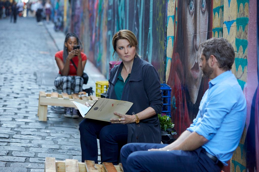 woman and man sitting down in street
