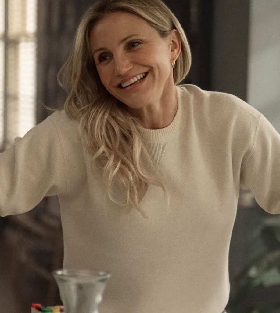 Cameron Diaz mengenakan sweter krem ​​di belakang beraksi