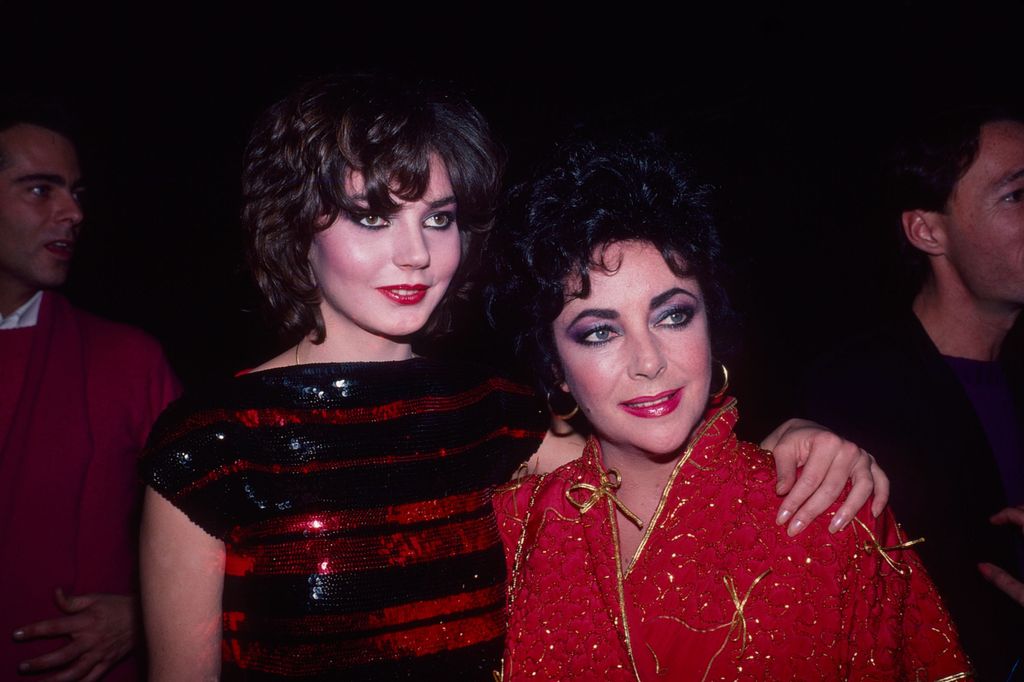 Maria Burton standing with Elizabeth Taylor in a red outfit