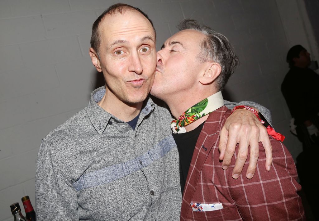 Alan Cumming kissing husband Grant Shaffer on the cheek