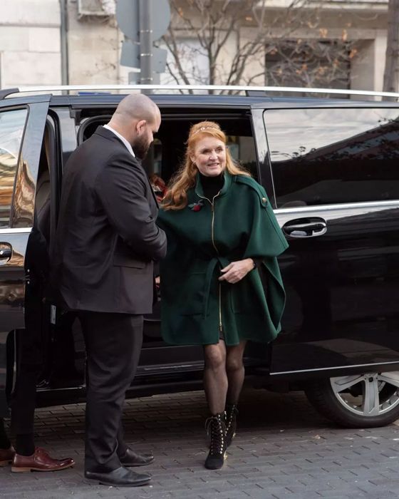 Sarah Ferguson emerging from a car wearing a green cape and lace up boots