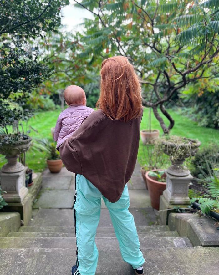 Backshot of Stacey Dooley holding a baby girl