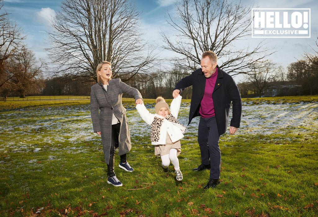 Ola and James Jordan swinging daughter Ella between them in park on frosty day