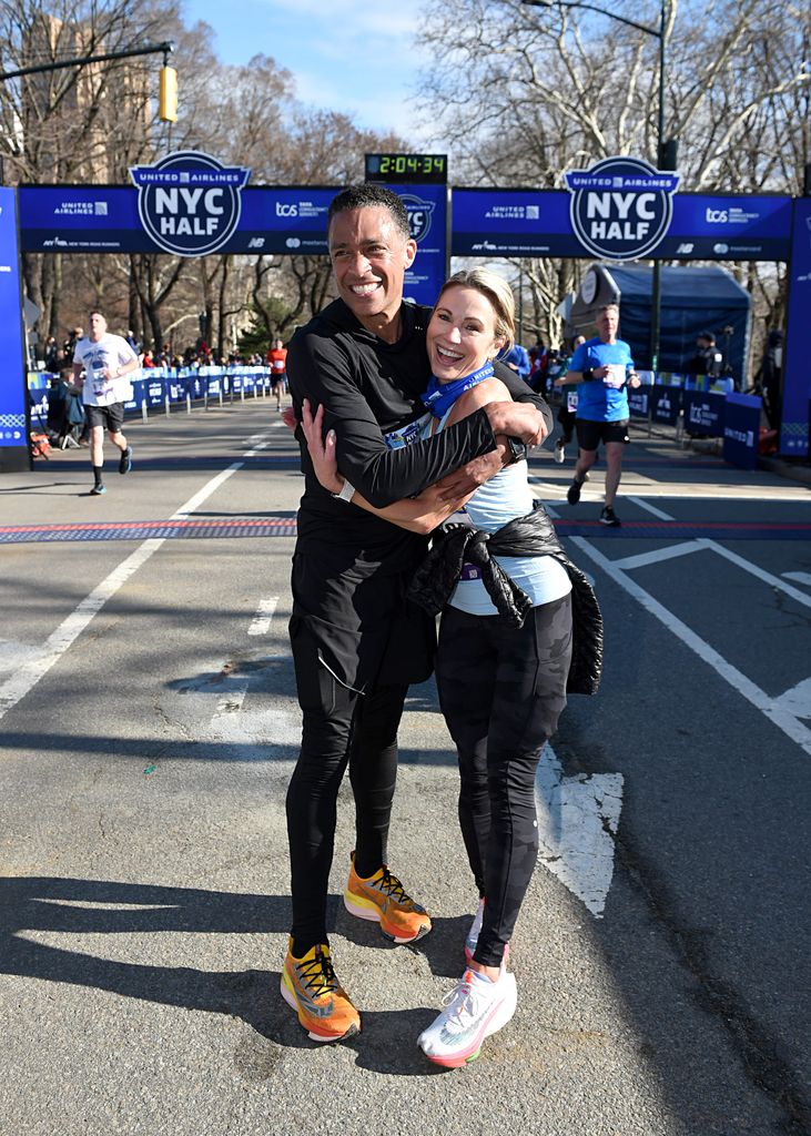 TJ Holmes et Amy Robach célèbrent alors qu'ils franchissent la ligne d'arrivée au cours de la semi-marathon 2022 United Airlines NYC le 20 mars 2022 