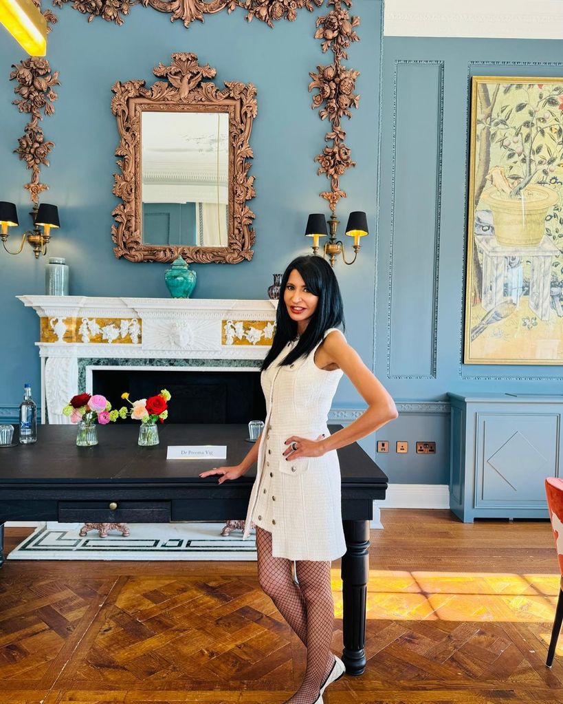 Woman in a blue office wearing a white dress