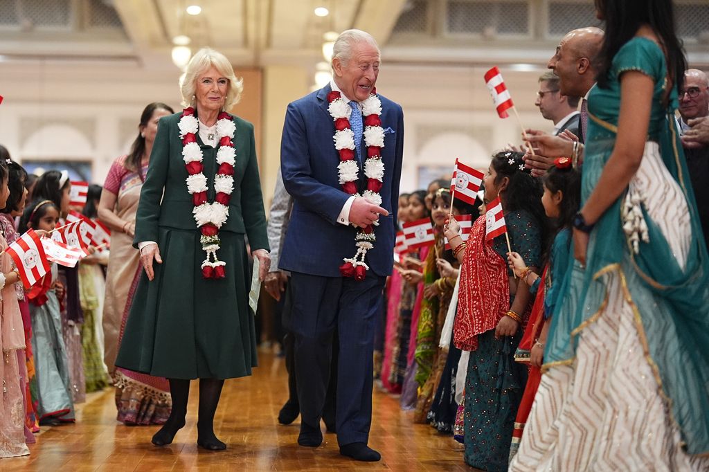 LONDON, ENGLAND - OCTOBER 29: King Charles III and Queen Camilla are greeted by children from the community, during a visit to BAPS Shri Swaminarayan Mandir (known as the 'Neasden Temple') in Neasden, London. There they observed spiritual ceremonies, met representatives from community and social impact initiatives the temple works with, before meeting members of the congregation. (Photo Aaron Chown - WPA Pool/Getty Images)