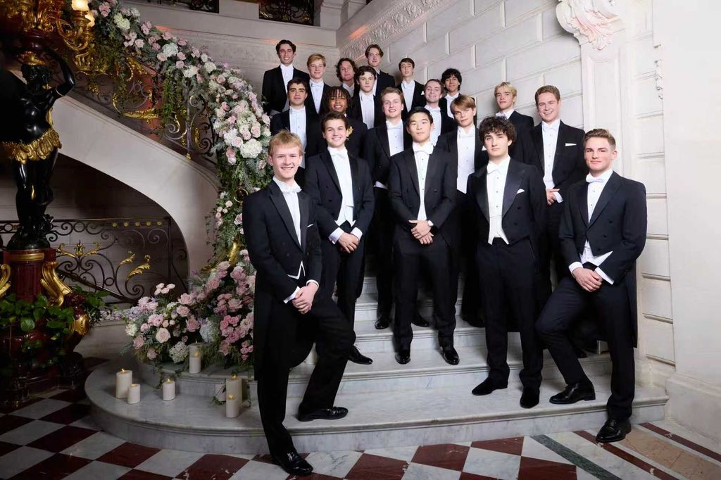 young men in white tie on grand staircase