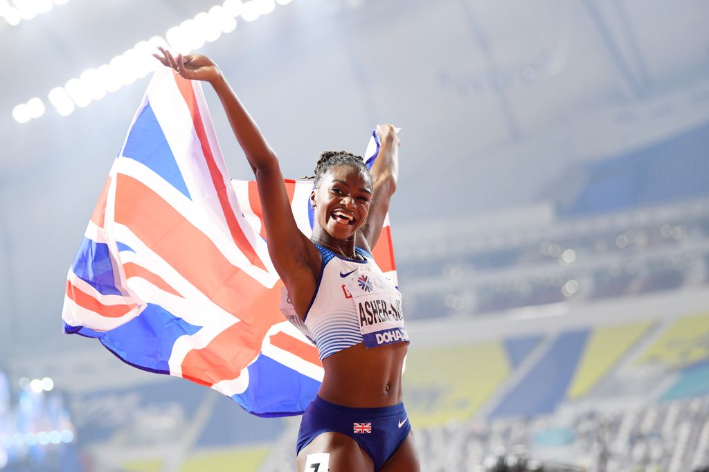 Dina Asher-Smith of Great Britain celebrates after winning gold in the Women's 200 metres final during day six of 17th IAAF World Athletics Championships Doha 2019 at Khalifa International Stadium on October 02, 2019 in Doha, Qatar