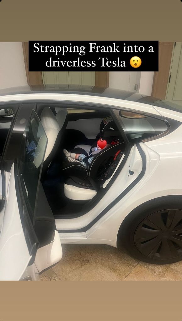 A photo of baby Frankie in the back of a Tesla
