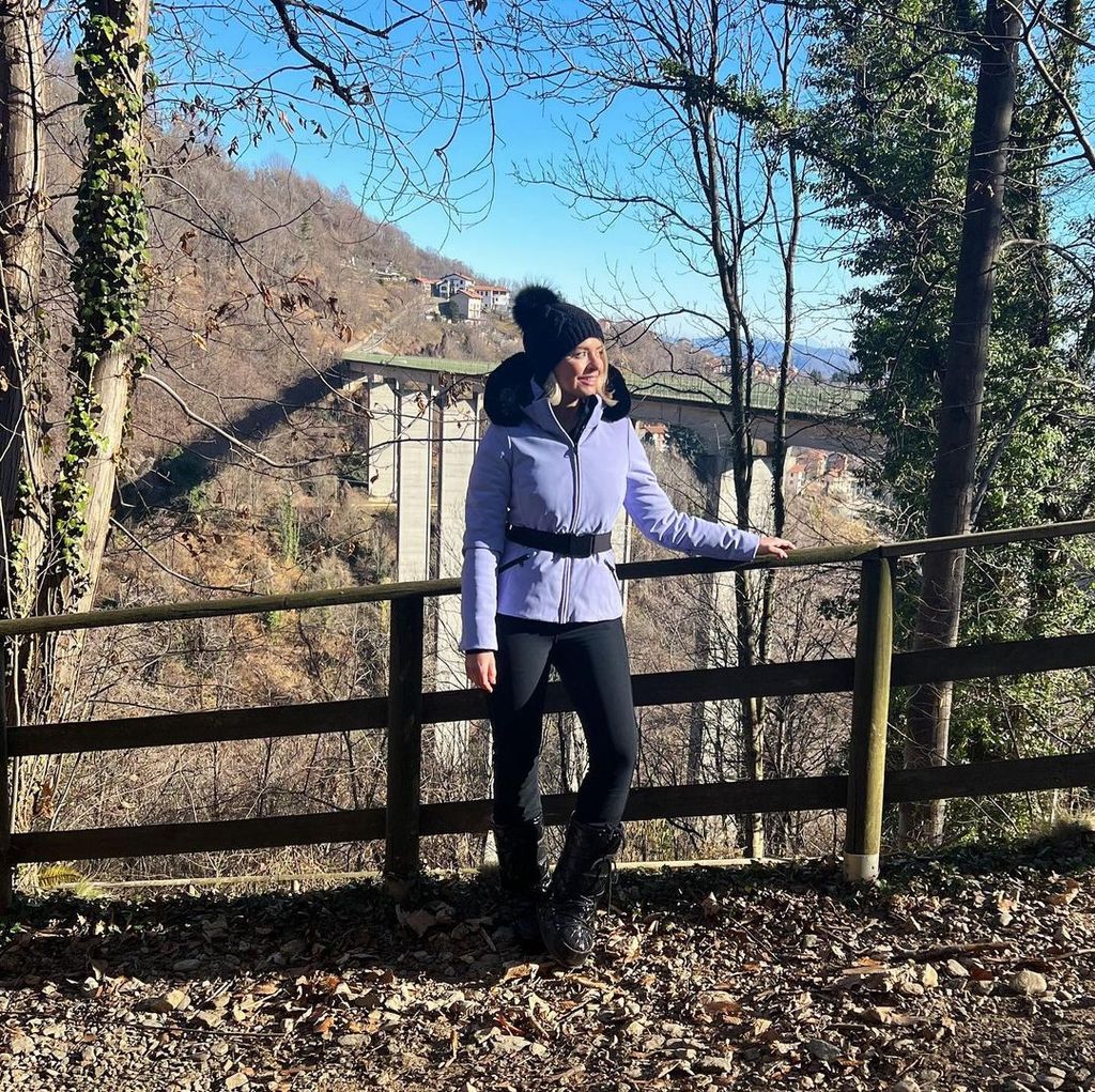Holly willoughby in blue ski jacket and black trousers posing in woods