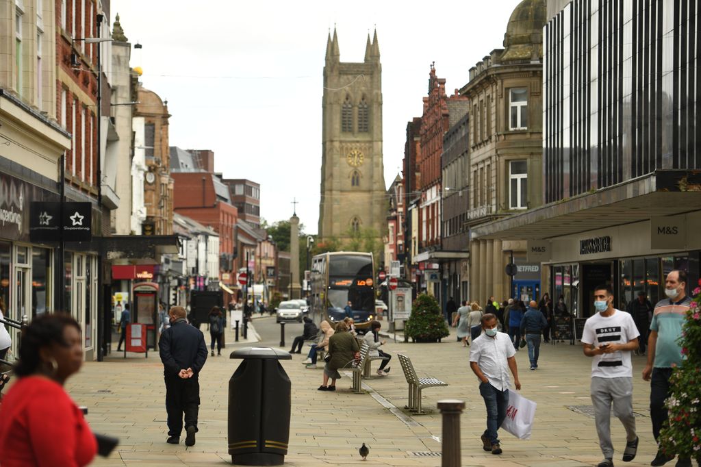 People walk in a high street in the centre of Bolton, northern England on September 9, 2020, as local lockdown restrictions are put in place due to a spike in cases of the novel coronavirus in the town. - The UK government, which controls health policy in England, imposed tougher restrictions on Bolton, near the northwest city of Manchester, after a "very significant rise" in cases. Bolton was found to have 120 cases per 100,000 people -- the highest in the country. (Photo by Oli SCARFF / AFP) (Photo by OLI SCARFF/AFP via Getty Images)