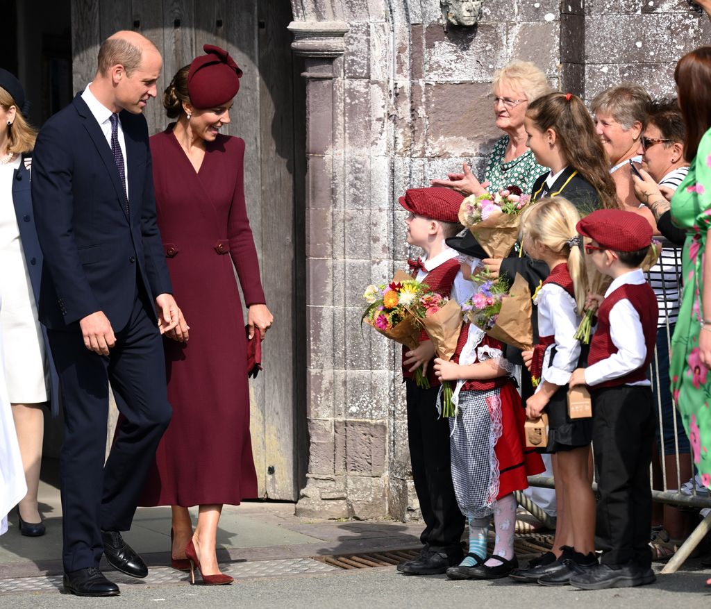 William and Kate walking past a group of children