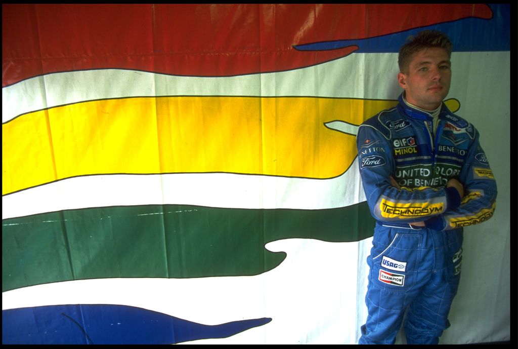 Jos Verstappen standing in front of a flag