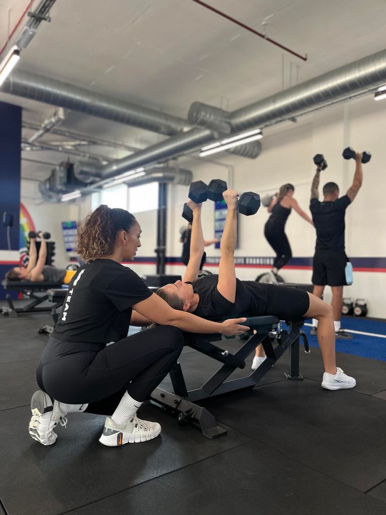 F45 personal trainer showing a client how to use dumbbells
