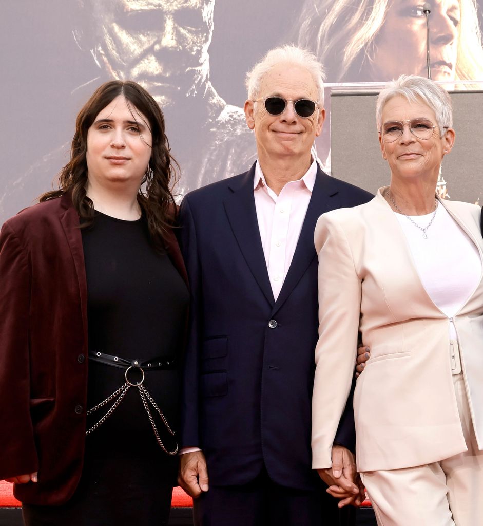 Ruby Guest, Christopher Guest, Jamie Lee Curtis all stood together smiling on the red carpet