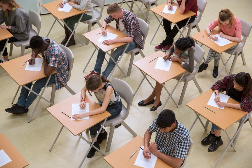 Students doing exams at individual desks