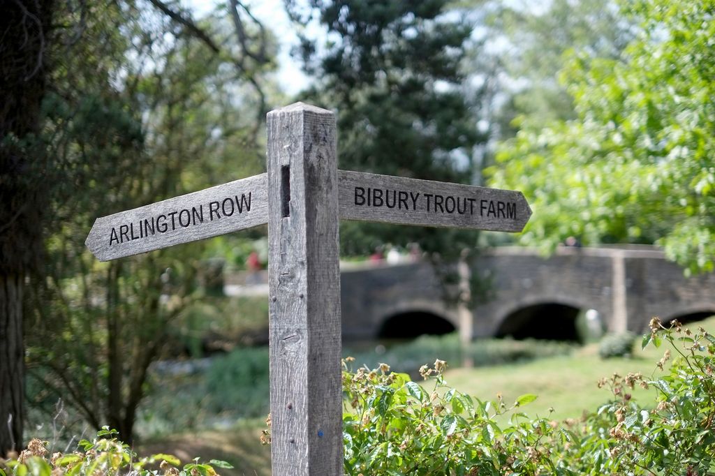 Signpost along the river in the historic Cotswold village of Bibury.