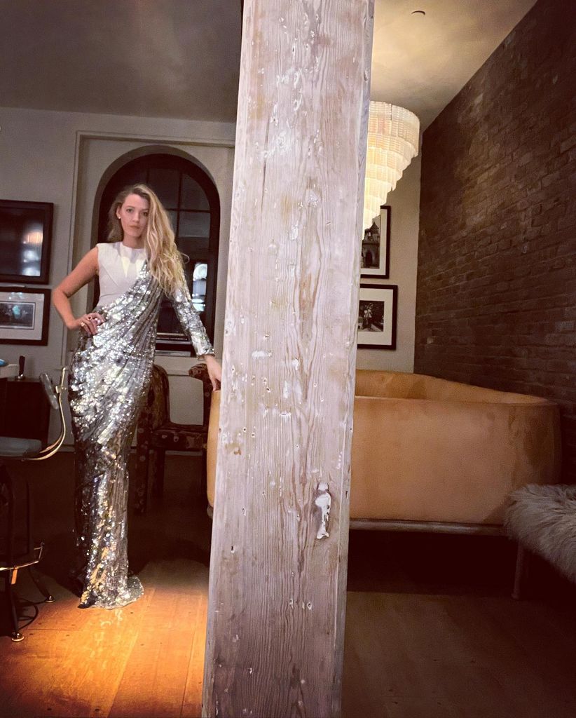 Blake in silver dress in dark living room