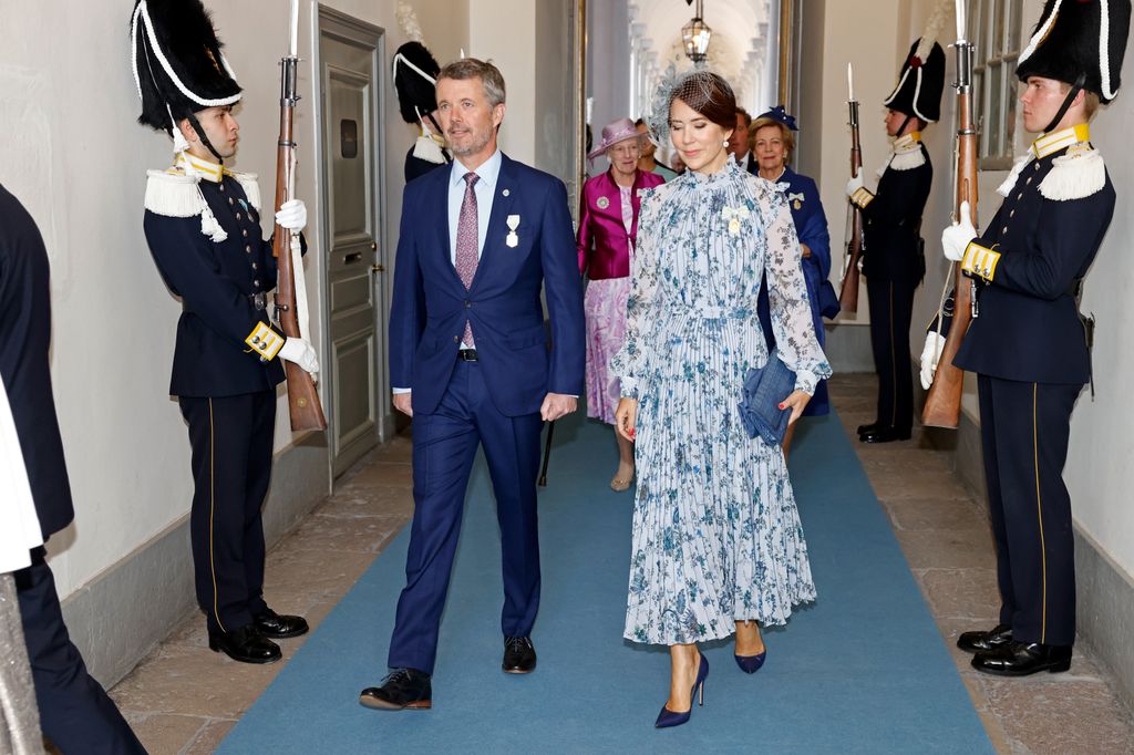 Queen Mary and king frederik walk by guards