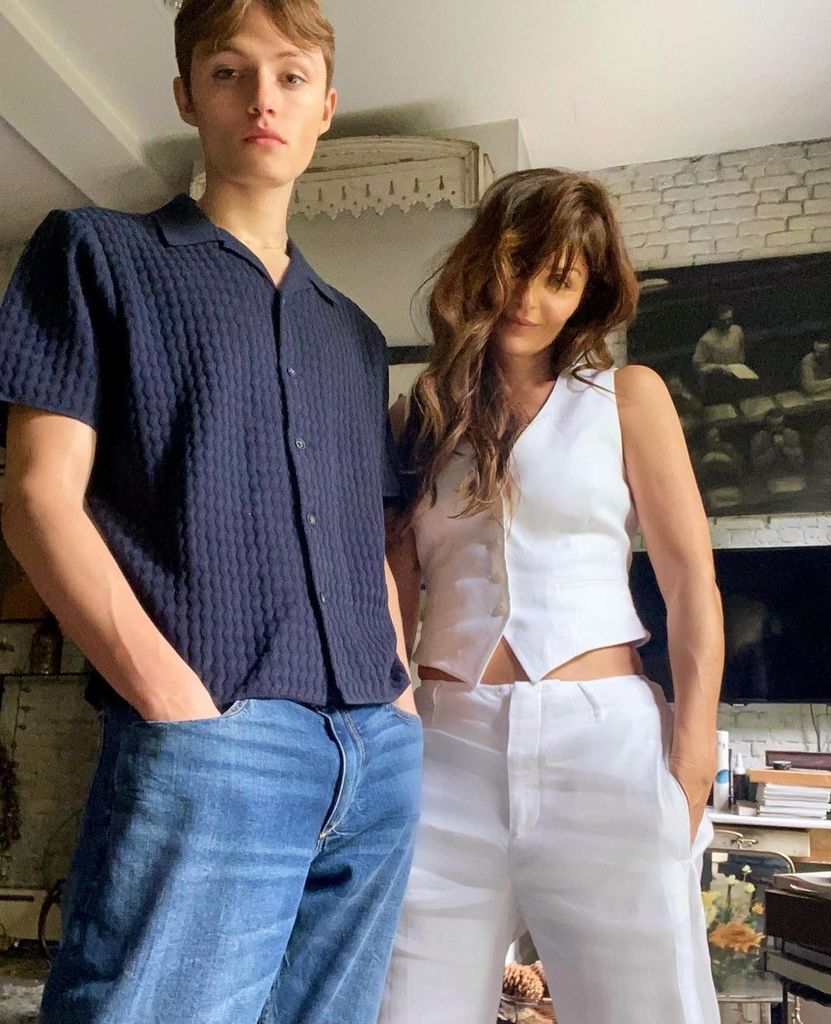 helena christensen in white waistcoat and pants posing with son mingus