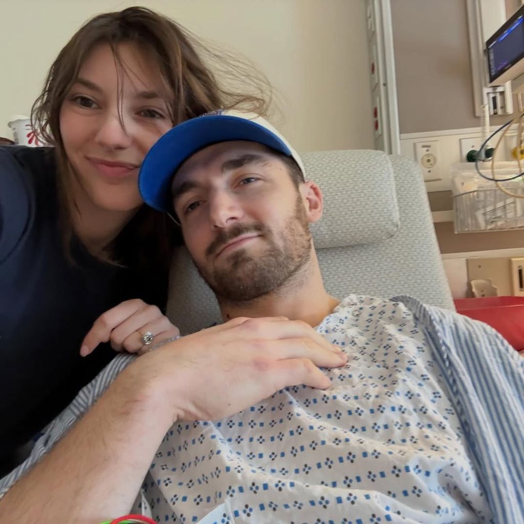 photo de Daniel Neeson dans un lit d'hôpital posant pour un selfie avec sa fiancée Natalie Ackerman