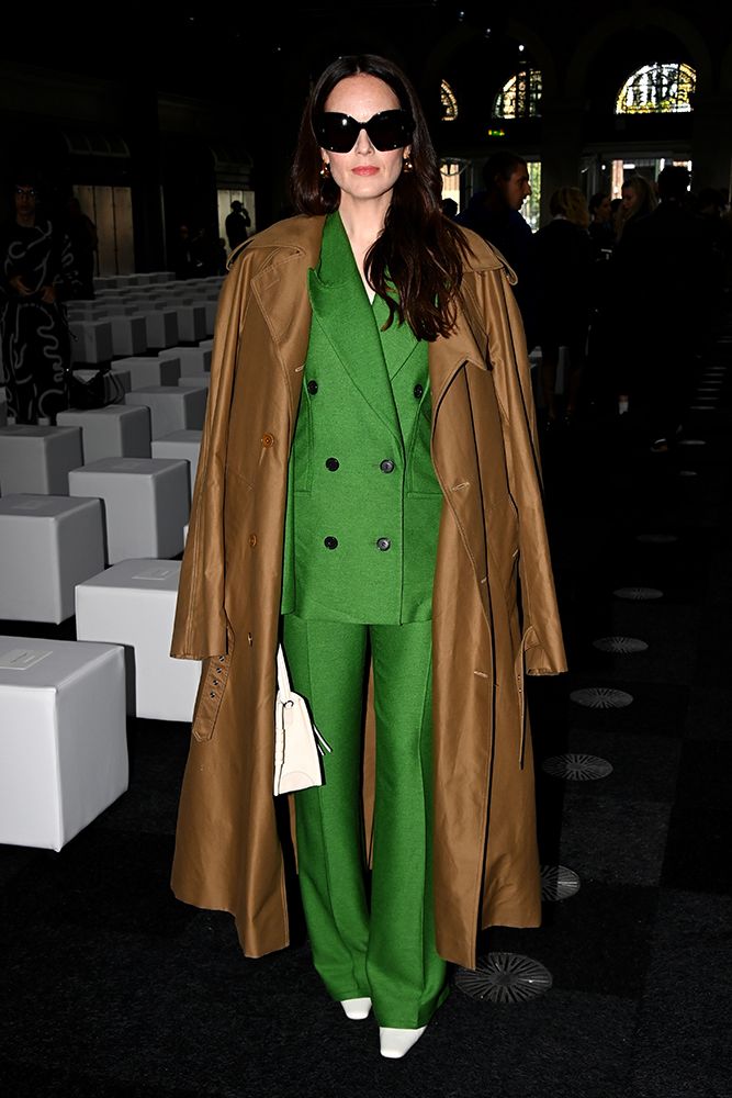 Michelle Dockery vestindo um impressionante terno verde com um casaco camelo