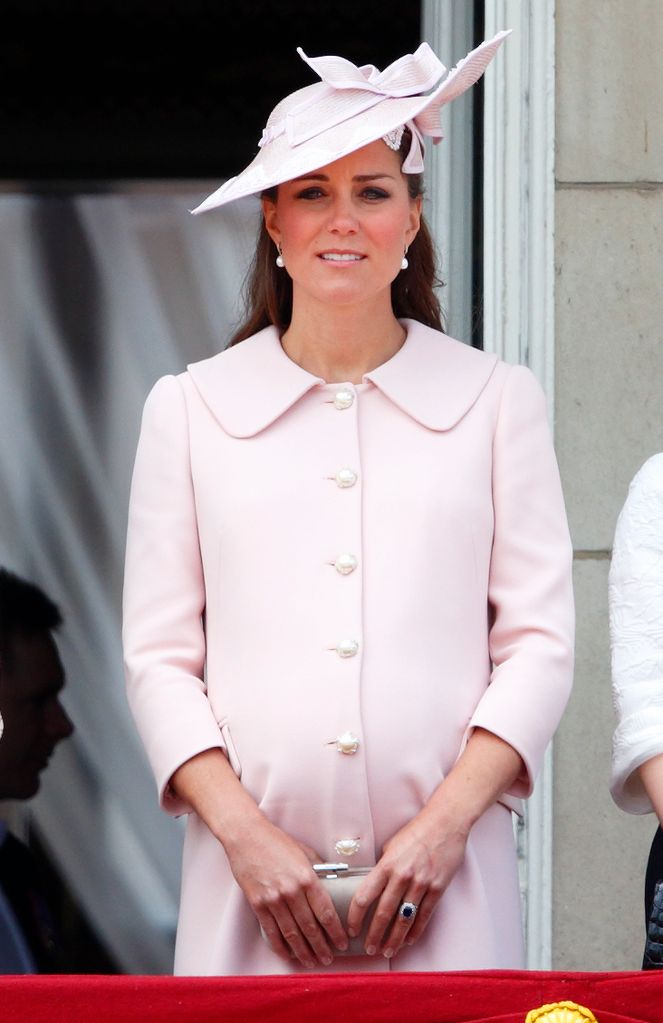 A pregnant Kate Middleton in a baby pink dress