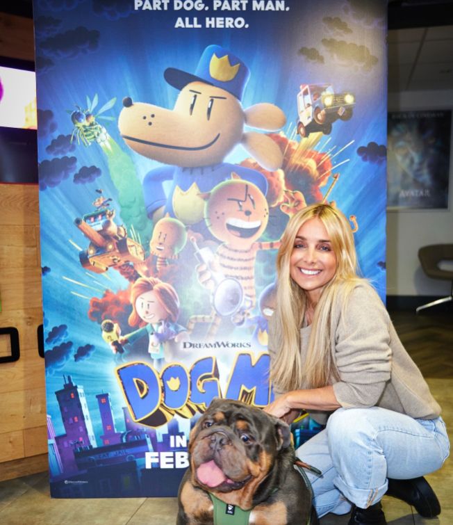 Louise Redknapp and a bulldog in front of a film poster