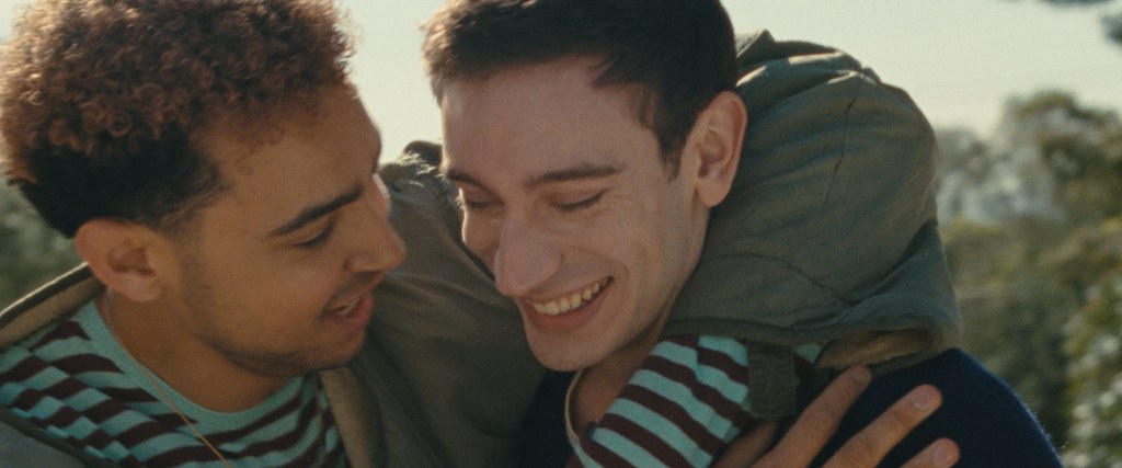 two men hugging, close-up