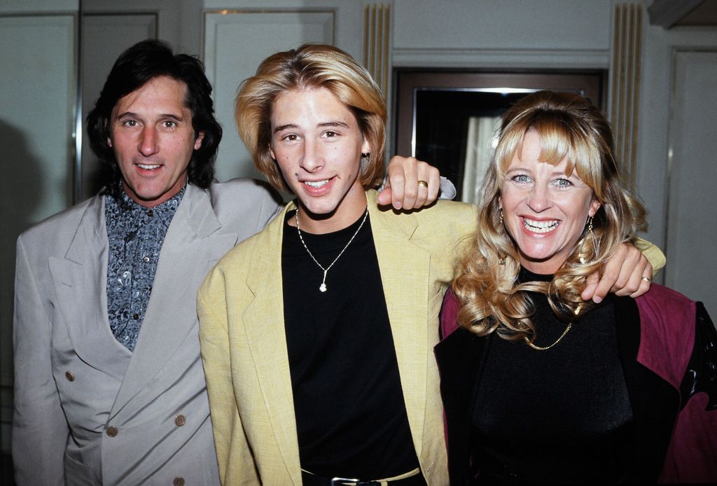 Young man posing alongside father and mother