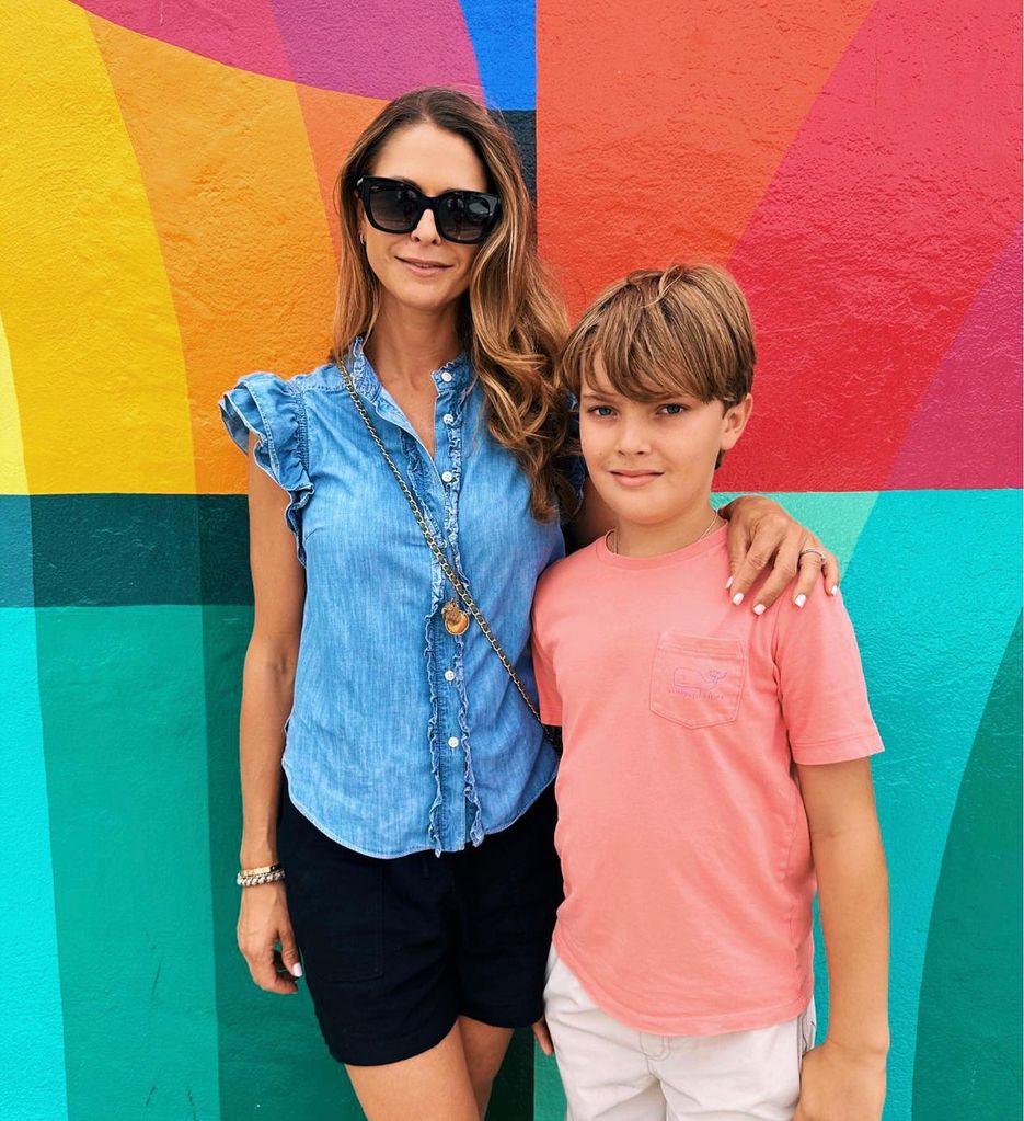 mother posing with son against mural 