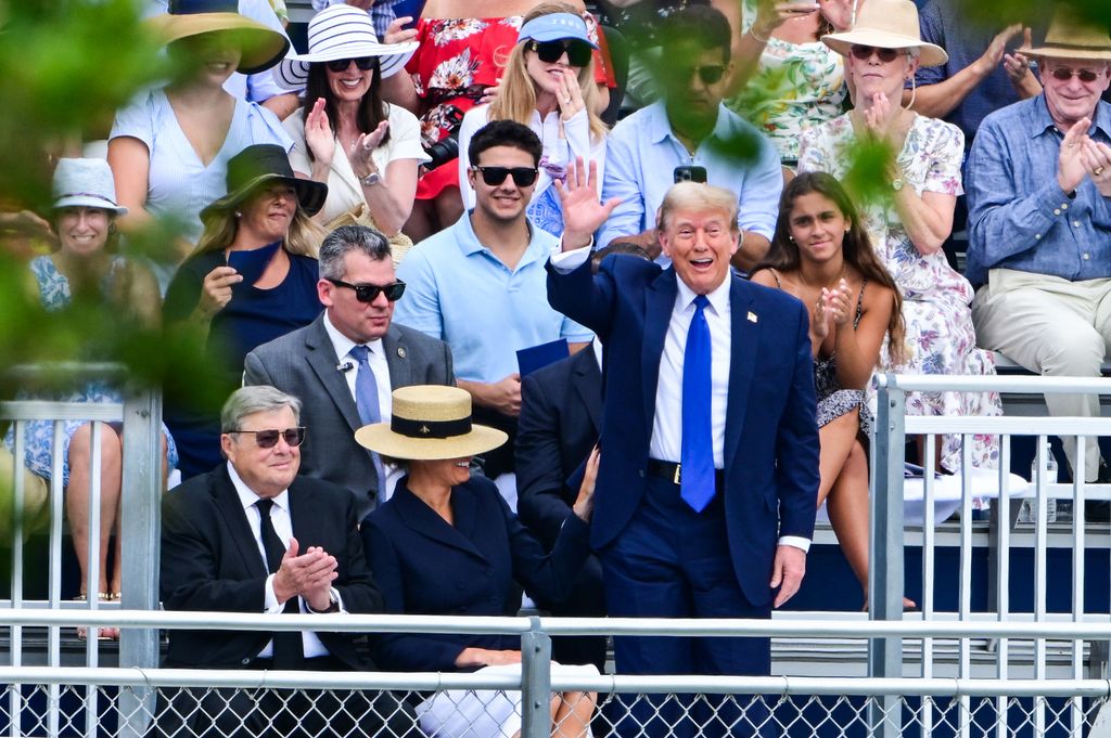 Former US President Donald Trump waves as he attends the graduation ceremony of his son, Barron Trump